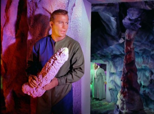 Image from Star Trek episode What Are Little Girls Made Of showing Kirk holding cave rock with Ruk in background